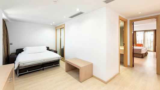 Rum med bäddsoffa och öppning mot sovrum och badrum. (AI-genererad text)