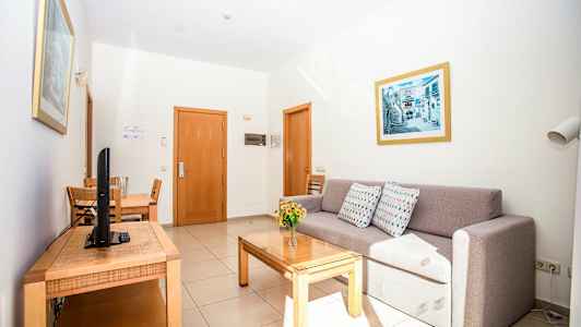 Ett hotellrum med en soffa, ett matbord och en TV. (AI-genererad text)