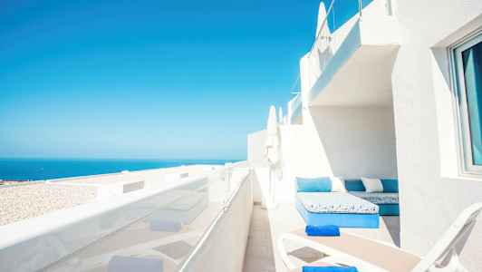 Terrass med solstolar och havsutsikt. (AI-genererad text)