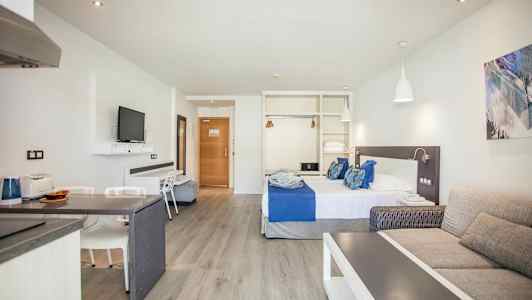 Hotellrum med säng, soffa och TV. (AI-genererad text)