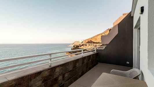 Balkong med utsikt över havet och klippor. (AI-genererad text)