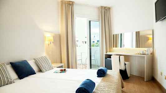 Hotelrum med två enkelsängar, balkong och skrivbord. (AI-genererad text)