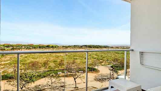 En balkong med utsikt över en park och ett öppet landskap. (AI-genererad text)