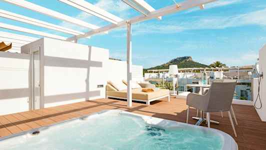 Terrass med jacuzzi, solsäng och utsikt mot grönskande berg. (AI-genererad text)