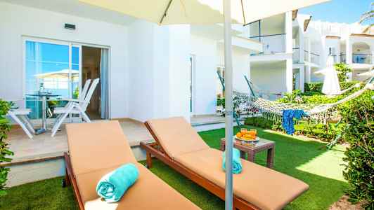 Bild av en trädgårdsterrass med solstolar, en hängmatta och en parasoll. (AI-genererad text)