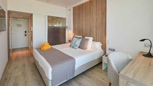 Ett hotellrum med en dubbelsäng, skrivbord och trädetaljer. (AI-genererad text)