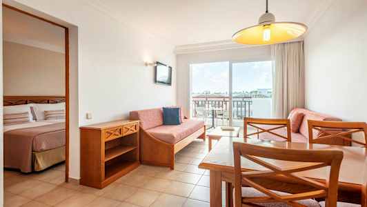 Lägenhetsinteriör med vardagsrum och en del av sovrummet synligt. (AI-genererad text)