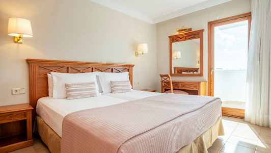 Dubbelrum med träinredning och utsikt mot en solig balkong. (AI-genererad text)