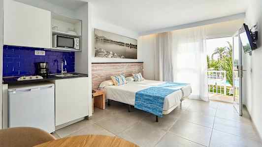 Bild på ett hotellrum med enkelsängar, pentry och en balkong med utsikt. (AI-genererad text)