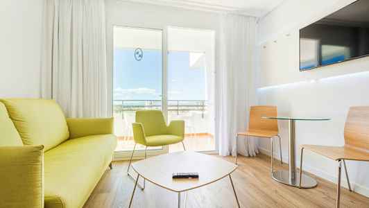 Ett modernt hotellrum med ljusa möbler och sittgrupp. (AI-genererad text)