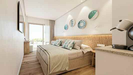 Ett modernt hotellrum med en dubbelsäng, dekorativa prydnadsskålar på väggen, en kaffemaskin och stora glasdörrar som leder till en balkong. (AI-genererad text)