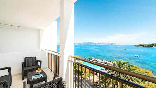 En balkong med sittmöbler som vetter mot havet. (AI-genererad text)