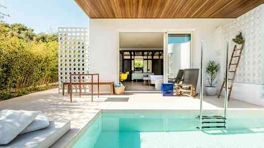 En modern uteplats med pool, sittmöbler och trädgårdsdekorationer. (AI-genererad text)