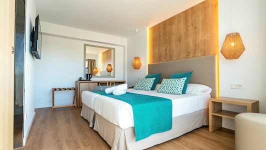 Ett hotellrum med dubbelsäng, turkosa detaljer och träinredning. (AI-genererad text)