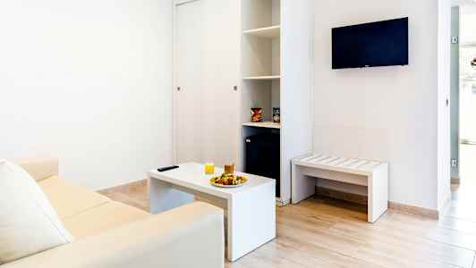 Interiör av ett vardagsrum med en soffa, soffbord och väggmonterad TV. (AI-genererad text)