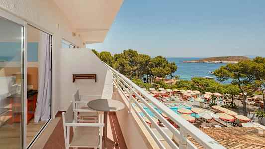 Balkong med sittmöbler, utsikt mot poolområde och hav. (AI-genererad text)