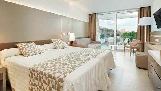 Modernt hotellrum med dubbelsäng och balkong. (AI-genererad text)