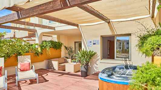 Terrass med utomhusmöbler, växter och en bubbelpool. (AI-genererad text)