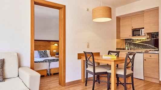 Ett rum med kök och matbord samt utsikt mot sovrummet. (AI-genererad text)