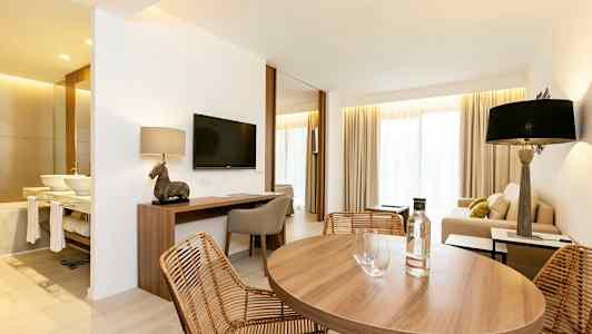 Rum med matbord, soffhörna och skrivbord. (AI-genererad text)