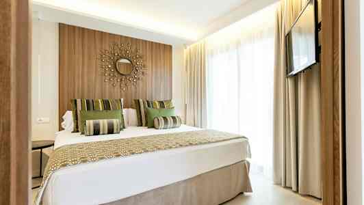 Modern hotellrum med dubbelsäng, väggdekoration och TV. (AI-genererad text)