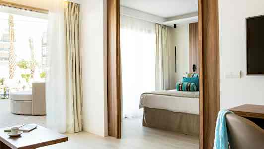 Modernt hotellrum med ljus inredning, mycket dagsljus och en bekväm säng. (AI-genererad text)