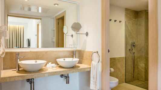 Badrum med två handfat och dusch. (AI-genererad text)