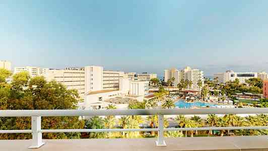 Hotel och poolområde sett från en balkong. (AI-genererad text)