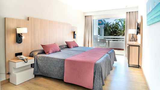 Ett hotellrum med två enkelsängar, en balkong och modern inredning. (AI-genererad text)