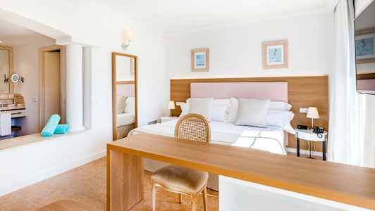 Ljust och rymligt hotellrum med dubbelsäng, skrivbord och stol. (AI-genererad text)