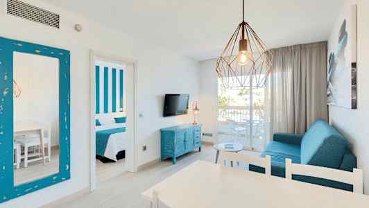 Ett vardagsrum med blå möbler, en hängande lampa och en öppen balkong. (AI-genererad text)