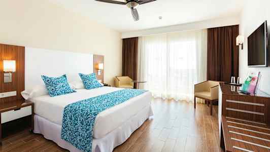 Hotellrum med en dubbelsäng, blåa textilier och en modern inredning. (AI-genererad text)