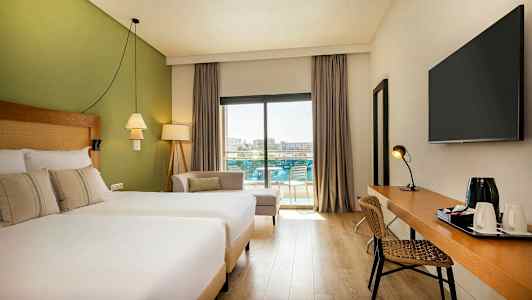 Modernt hotellrum med fönster mot balkong och poolområdet. (AI-genererad text)