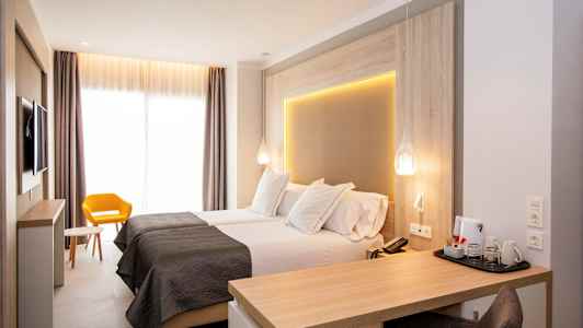 Modernt hotellrum med två enkelsängar, skrivbord och gul stol. (AI-genererad text)