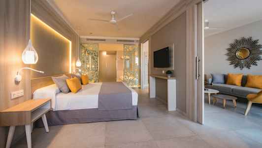 Hotellrum med säng, sittgrupp och TV. (AI-genererad text)