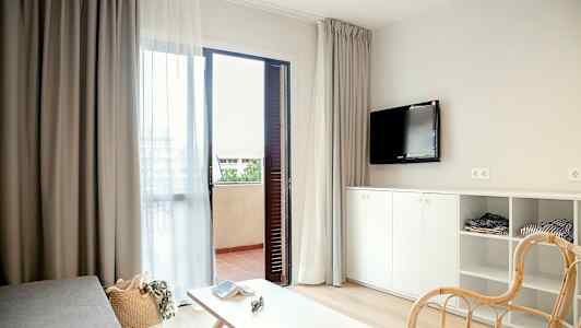 Modernt möblerat hotellrum med öppen dörr till balkong. (AI-genererad text)