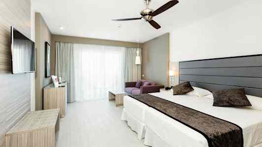 Bild av ett hotellrum med en säng, en soffa och en TV. (AI-genererad text)