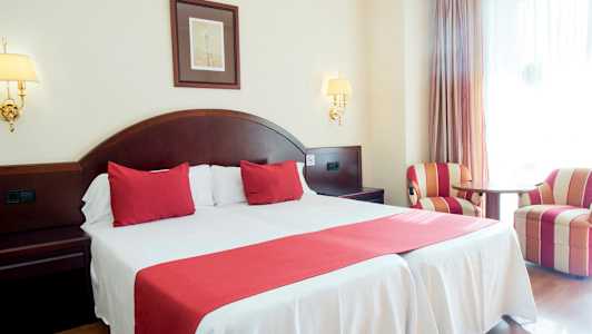 Dubbelrum med röd inredning och två fåtöljer. (AI-genererad text)