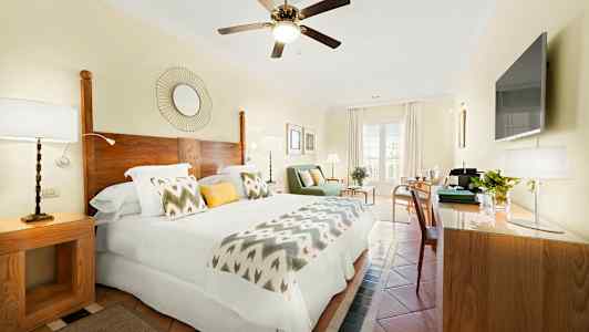 Ett ljust hotellrum med dubbelsäng, trädetaljer och modern inredning. (AI-genererad text)