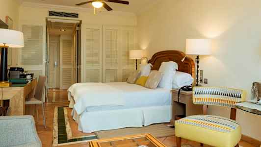 Hotellrum med dubbelsäng, skrivbord och stol. (AI-genererad text)