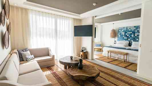 Bild av ett ljust och modernt hotellrum med vardagsrumsmöbler och en säng. (AI-genererad text)