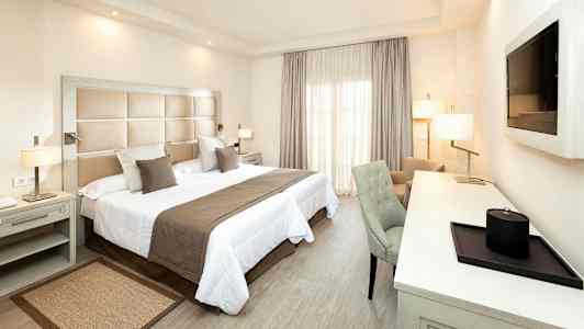 Ett hotellrum med en dubbelsäng, skrivbord och stol. (AI-genererad text)