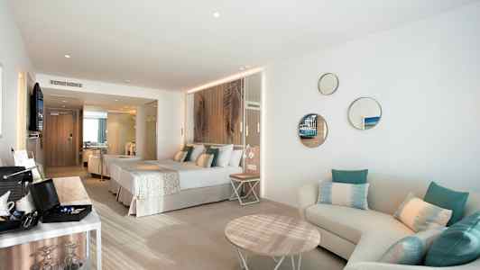 Modernt hotellrum med dubbelsäng, sittgrupp och inredningsdetaljer. (AI-genererad text)