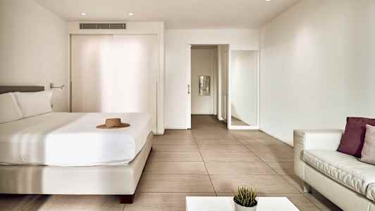 Ett modernt hotellrum med en säng, soffa och bord. (AI-genererad text)