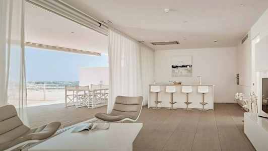 Bild av ett modernt vardagsrum med öppen planlösning, ljusa möbler och vy mot en terrass. (AI-genererad text)