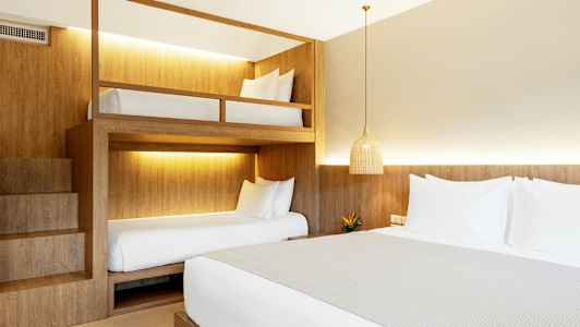 Ett hotellrum med en dubbelsäng och våningssängar. (AI-genererad text)