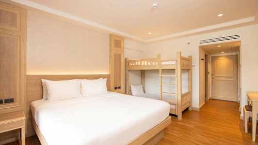 Hotellrum med en dubbelsäng och en våningssäng. (AI-genererad text)