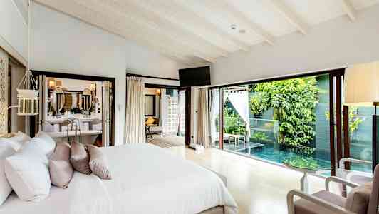 Sovrum med dubbelsäng som har ett fönster mot en privat pool och grönska. (AI-genererad text)