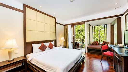 Hotellrum med dubbelsäng, sängbord och balkong med utsikt över grönska. (AI-genererad text)