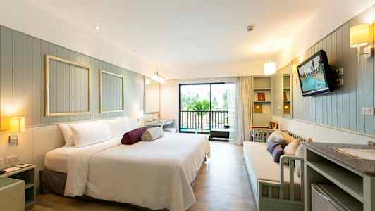 Ett rymligt hotellrum med modern möblering och en balkong. (AI-genererad text)